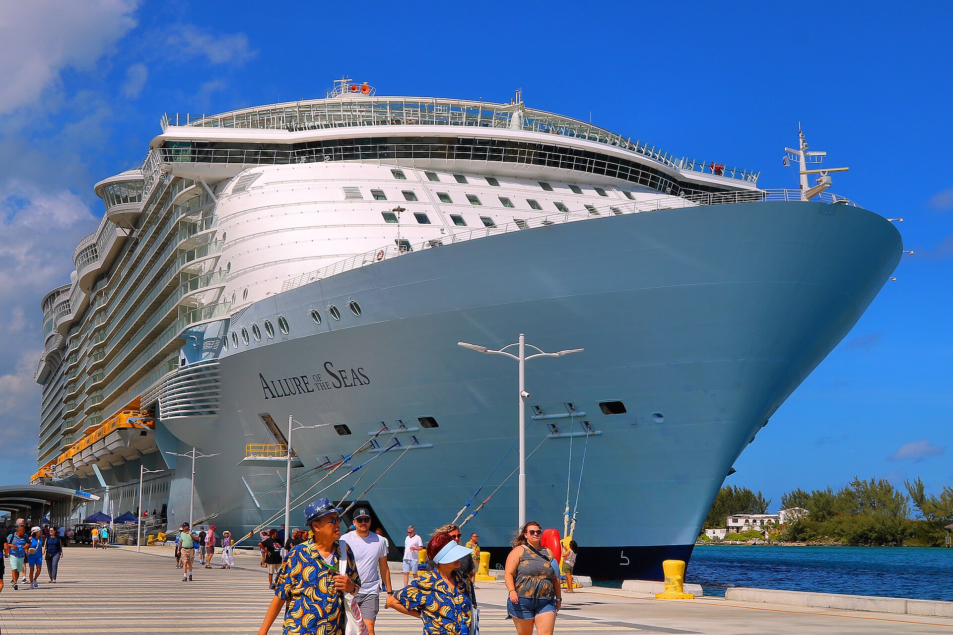 Allure of the Seas towering over the pier at Nassau under a bright blue sky