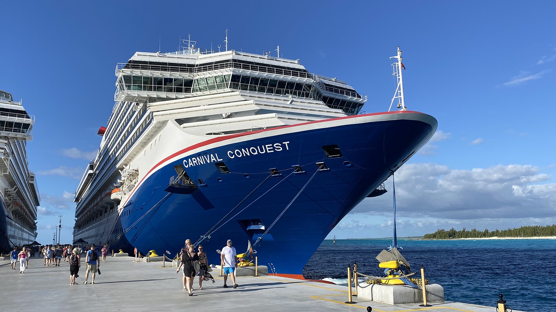 Blue-hulled Carnival Conquest docked at Celebration Key on Grand Bahama under a bright blue sky