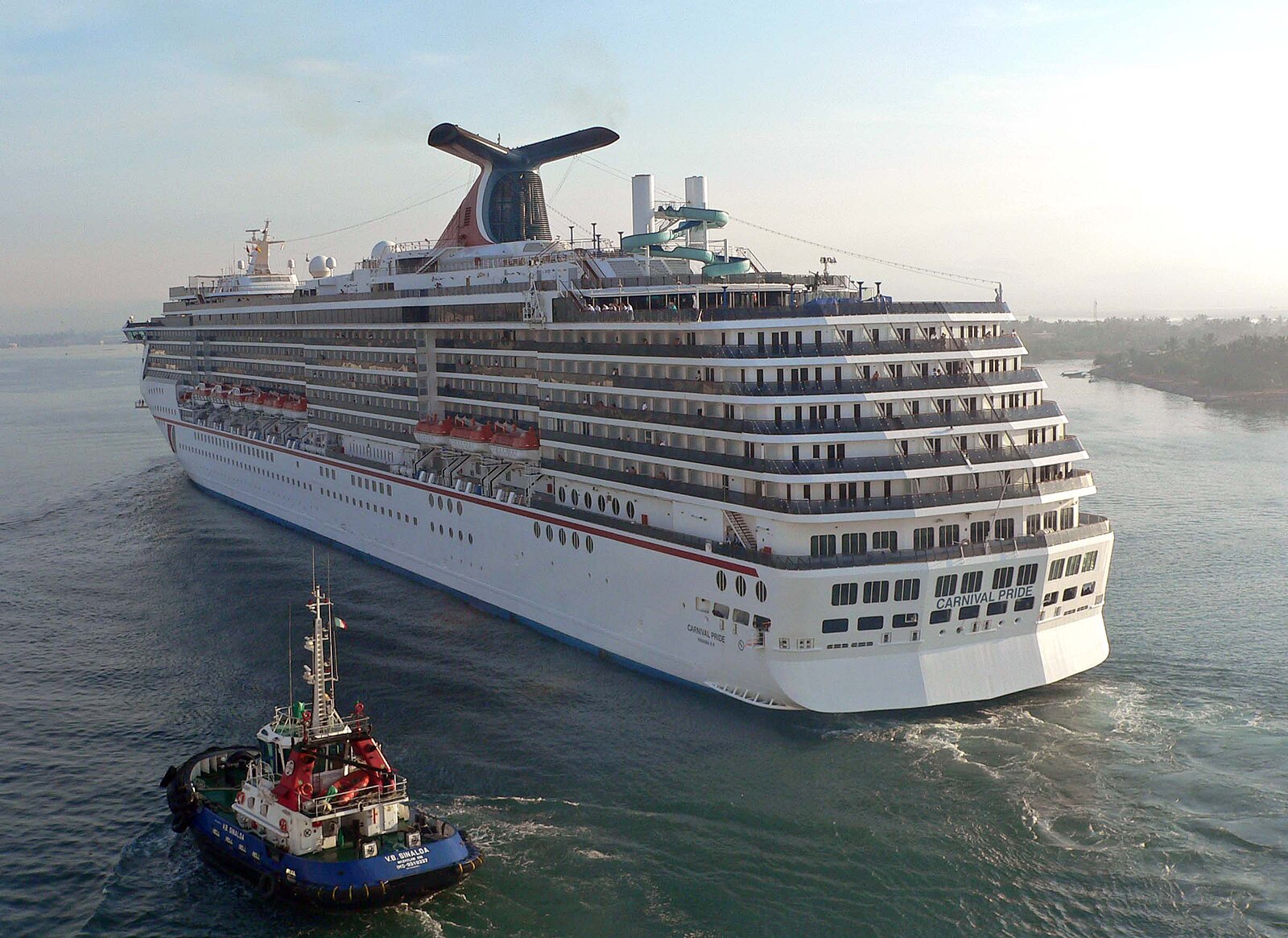 Carnival Pride cruise ship arriving at Mazatlan with a blue and red tugboat alongside