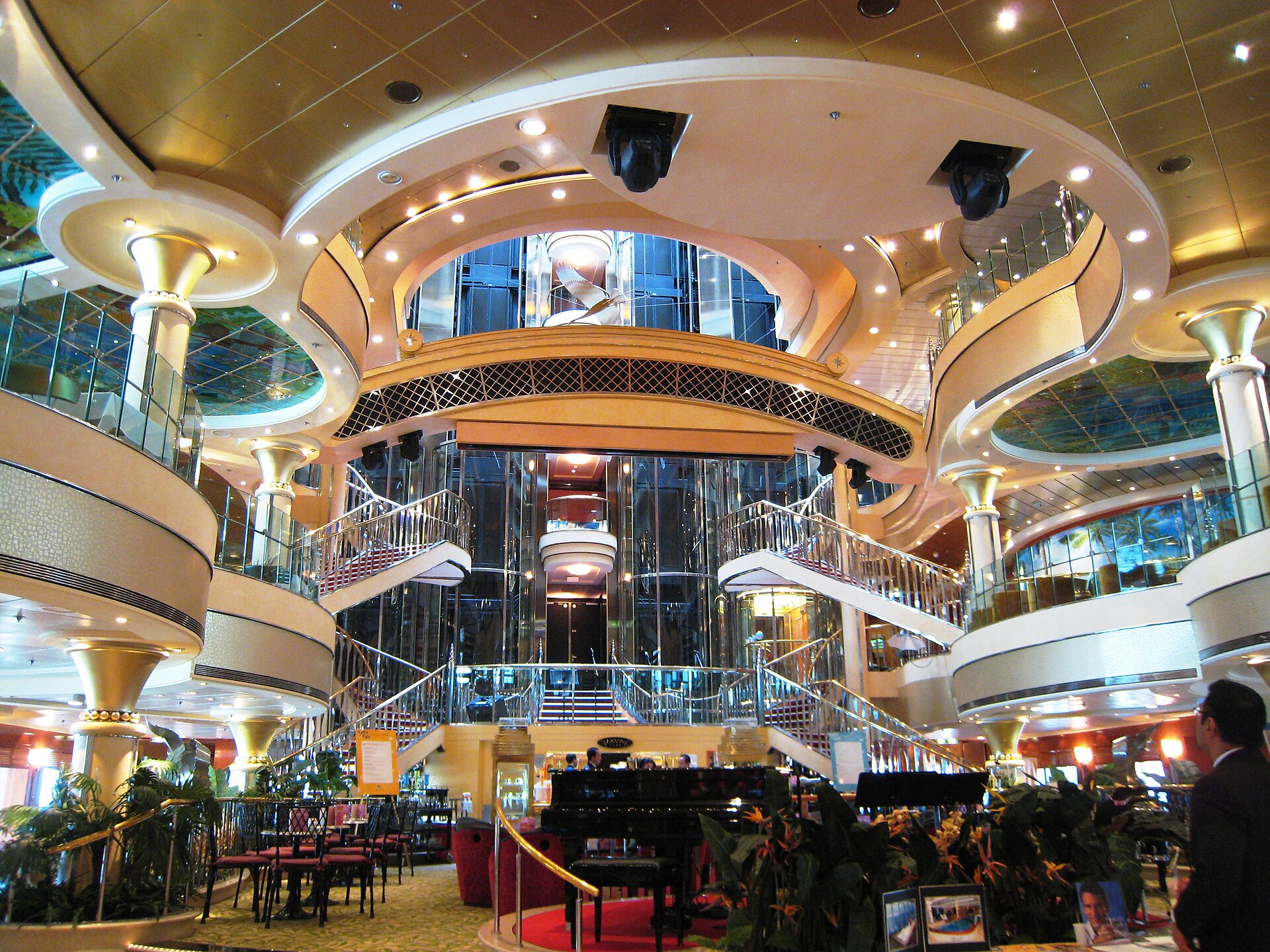 Golden multi-deck atrium aboard Norwegian Star with curved balconies and a grand staircase