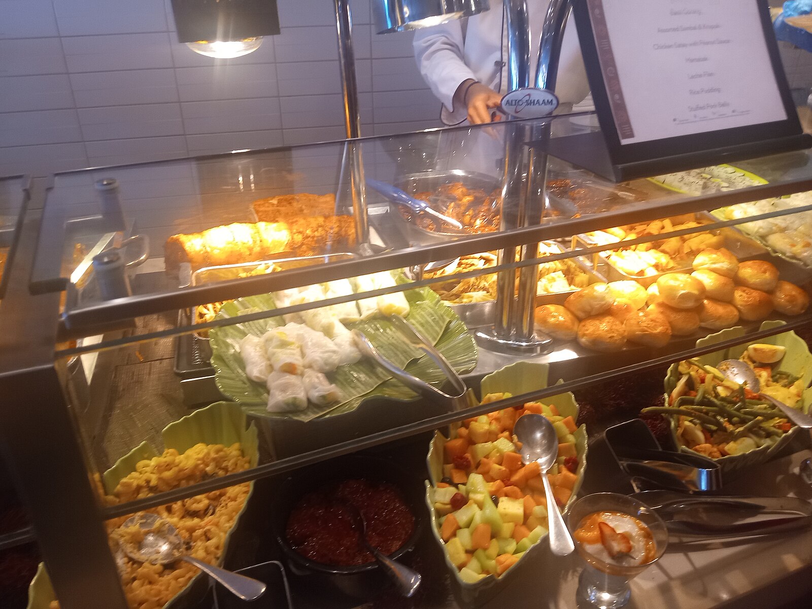 Cruise ship buffet counter with fresh cut melon, dumplings, bread rolls and hot dishes