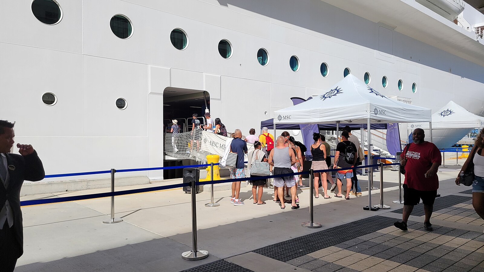 Passengers queuing at a cruise ship gangway entrance on the pier in Nassau
