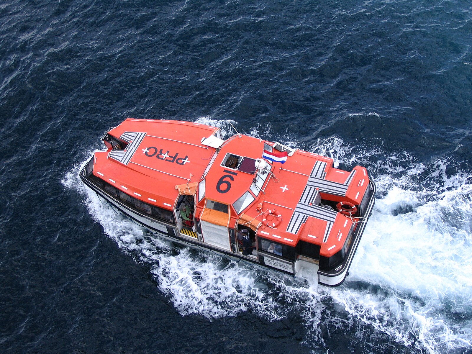 Orange cruise ship tender boat crossing blue water back to the ship at Cabo San Lucas