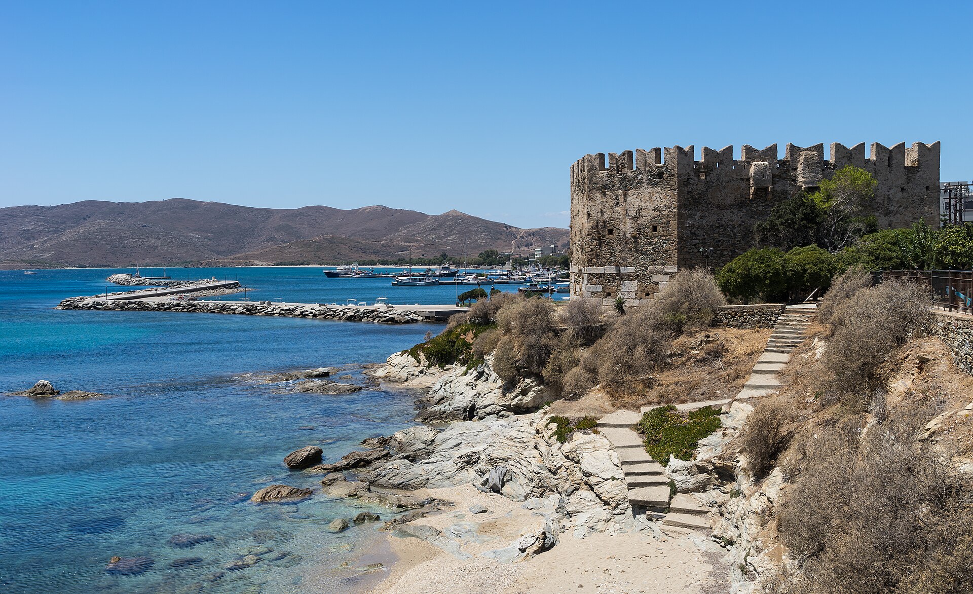 Turquoise water and the Bourtzi castle at the harbour of Karystos on the Greek island of Evia