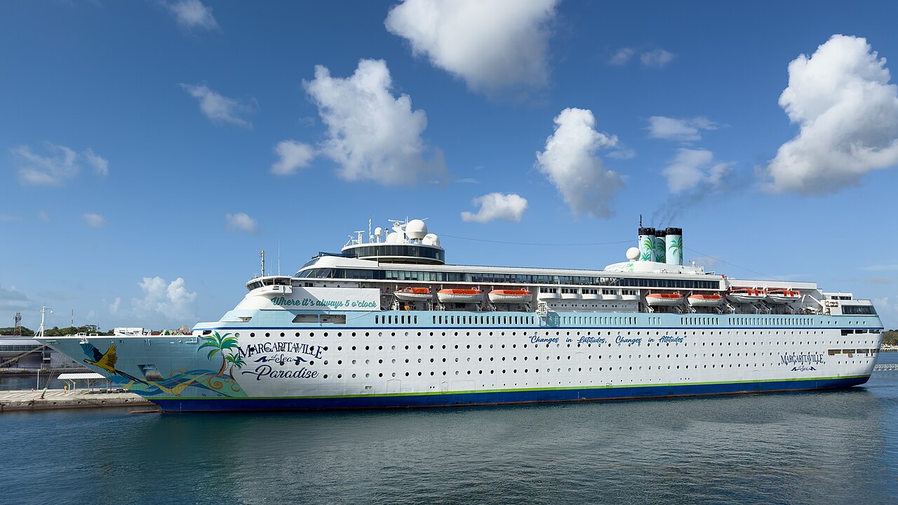 Margaritaville at Sea Paradise docked in Nassau under a bright blue sky with white clouds