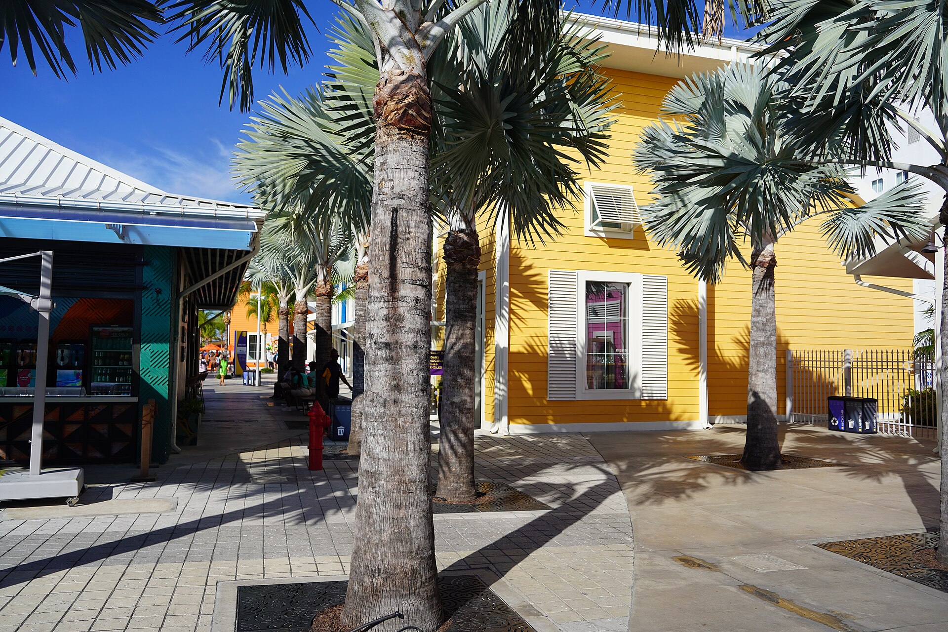 Bright yellow shopfronts and palm trees at Nassau Cruise Port in the Bahamas