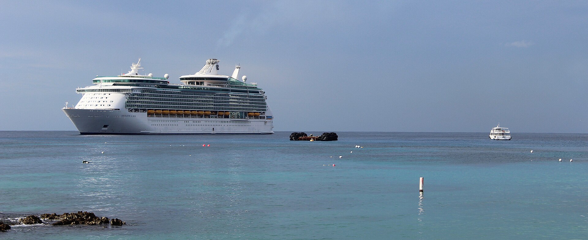 Navigator of the Seas anchored off Grand Cayman with tender boats crossing turquoise water