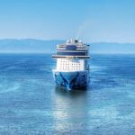 Norwegian Bliss cruise ship sailing into Puerto Vallarta harbor on bright blue water