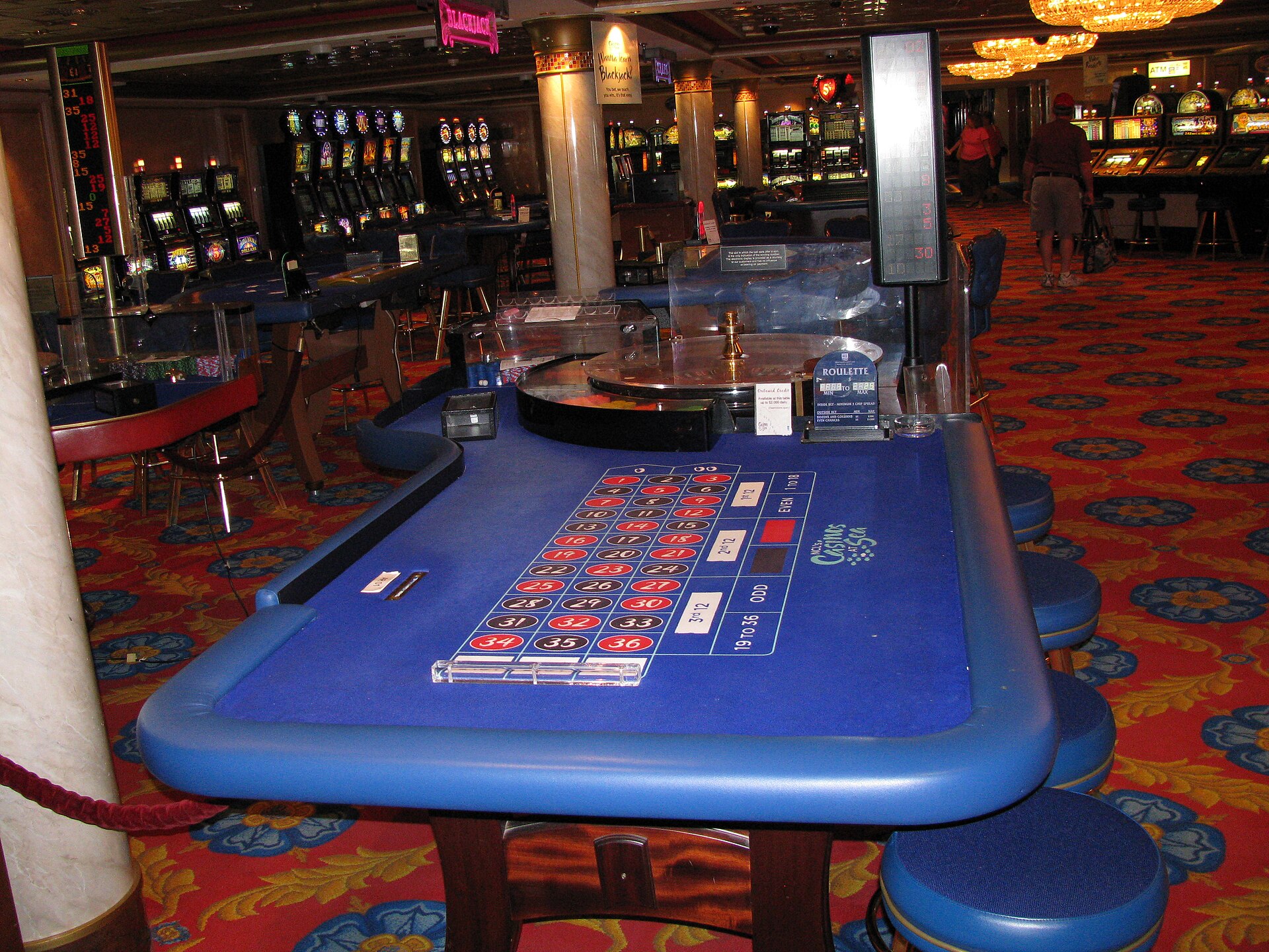 Blue roulette table and slot machines in the casino of the Norwegian Dawn cruise ship