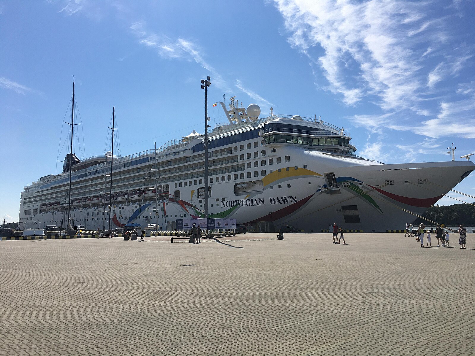 Norwegian Dawn alongside the pier in Klaipeda, Lithuania, with passengers walking on the quay