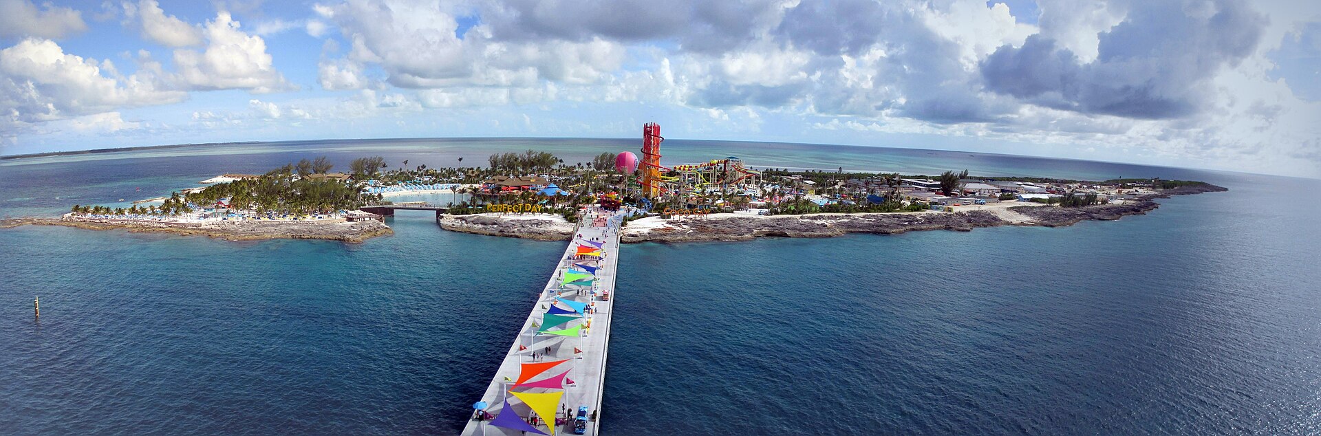 Panoramic view of a Caribbean cruise port with colorful umbrellas along the pier
