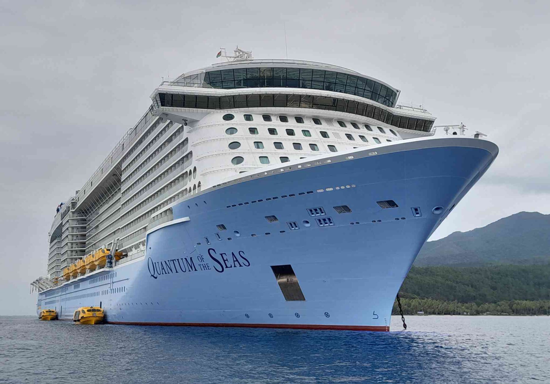 Quantum of the Seas at anchor, bright blue bow and yellow tenders