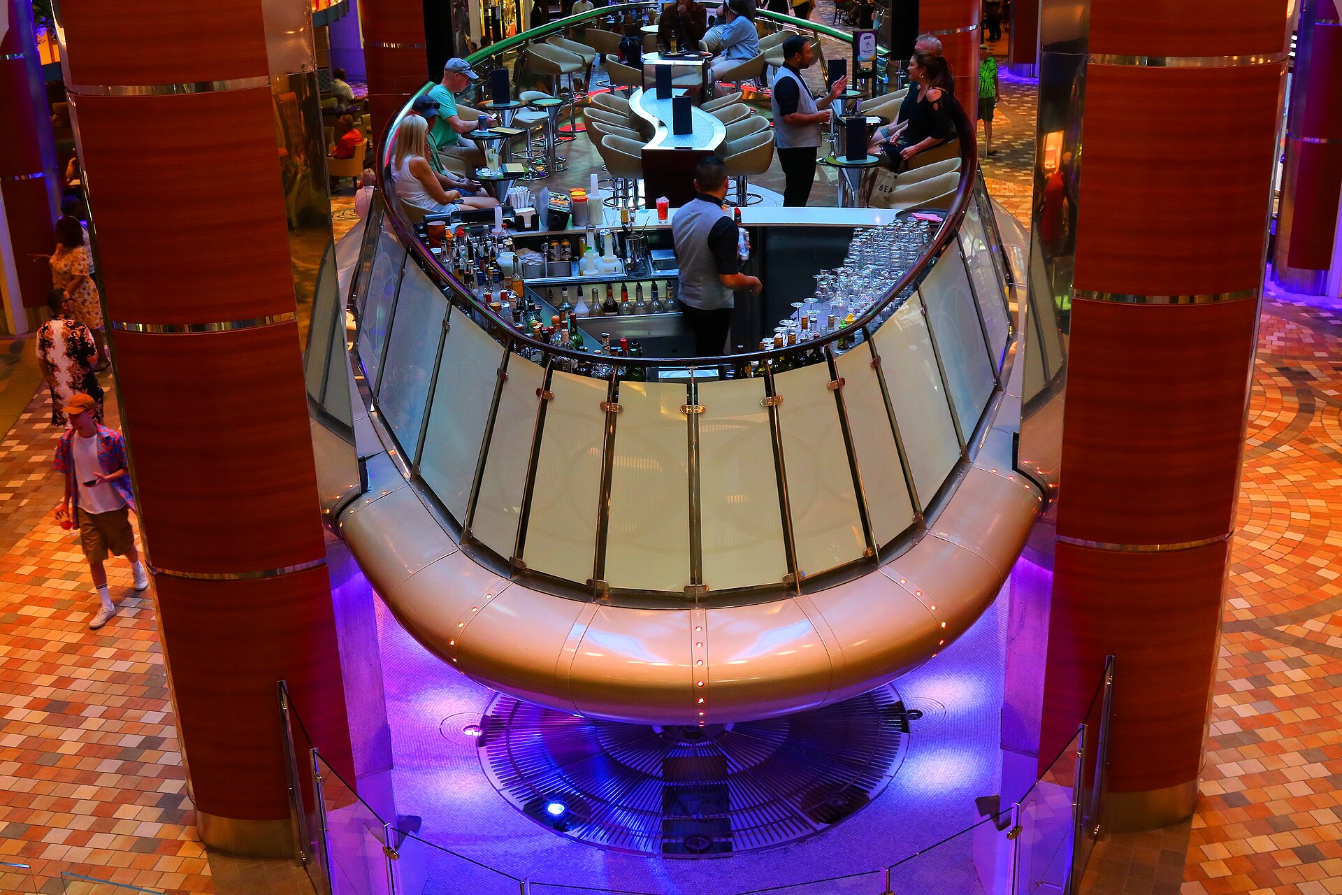 The moving Rising Tide Bar lit in purple on the Royal Promenade of Royal Caribbean's Allure of the Seas