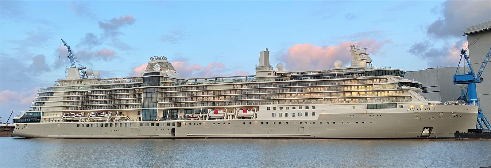 Silversea's Silver Nova moored at the Meyer Werft shipyard under a pink and blue sunset sky