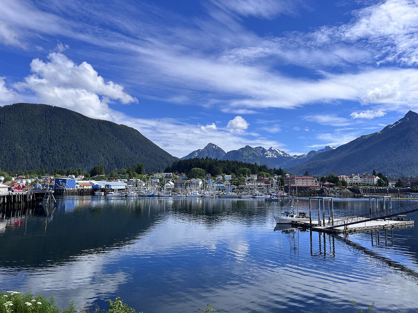 The town of Sitka, Alaska seen across its harbor with snow-capped mountains behind