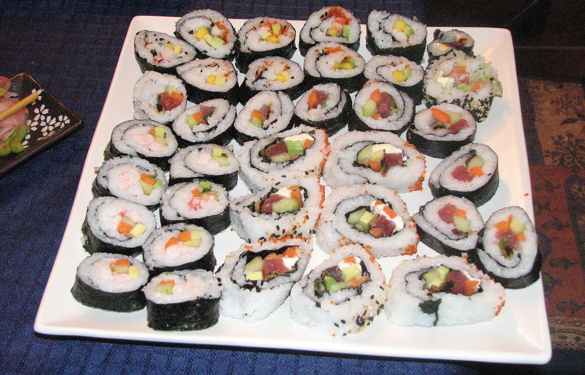 Square white platter of colourful maki sushi rolls