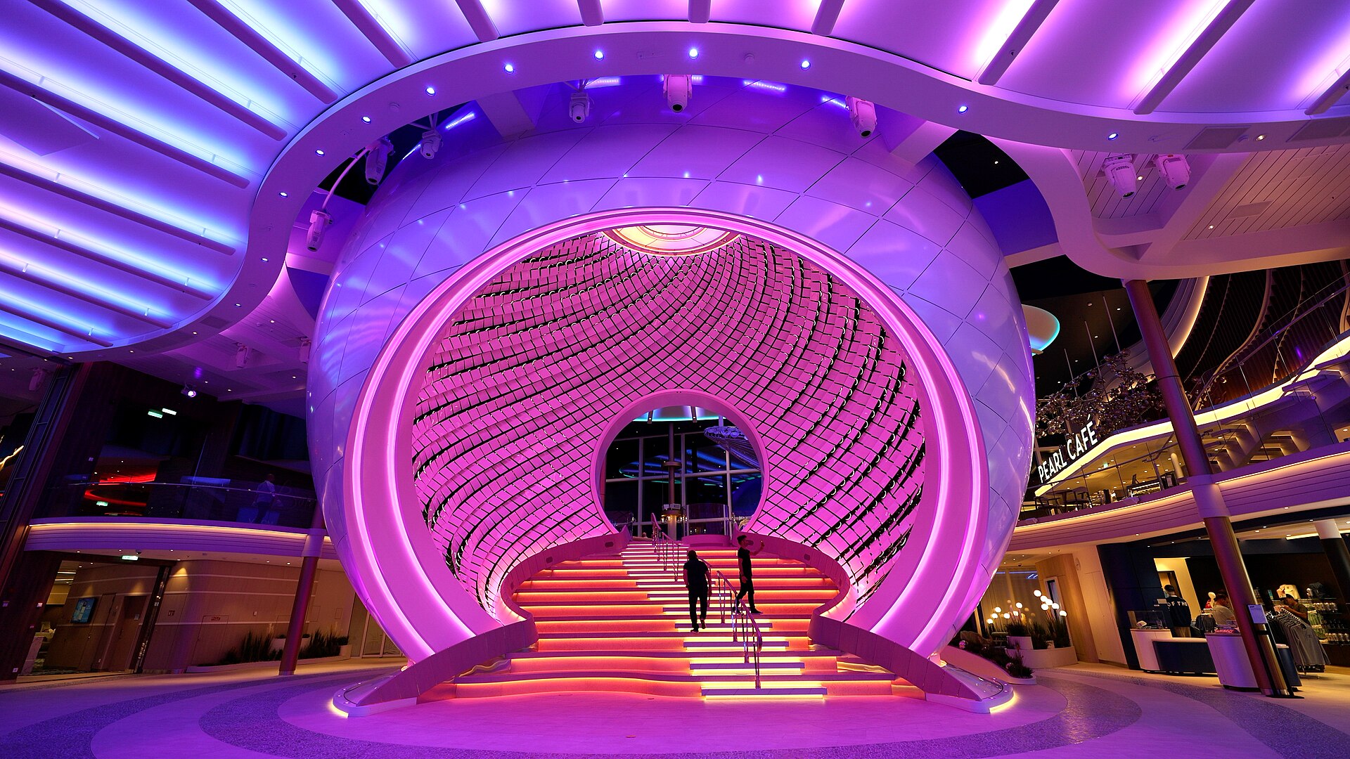 The Pearl, a giant glowing orb with a lit staircase through its centre, on the Royal Promenade of Icon of the Seas