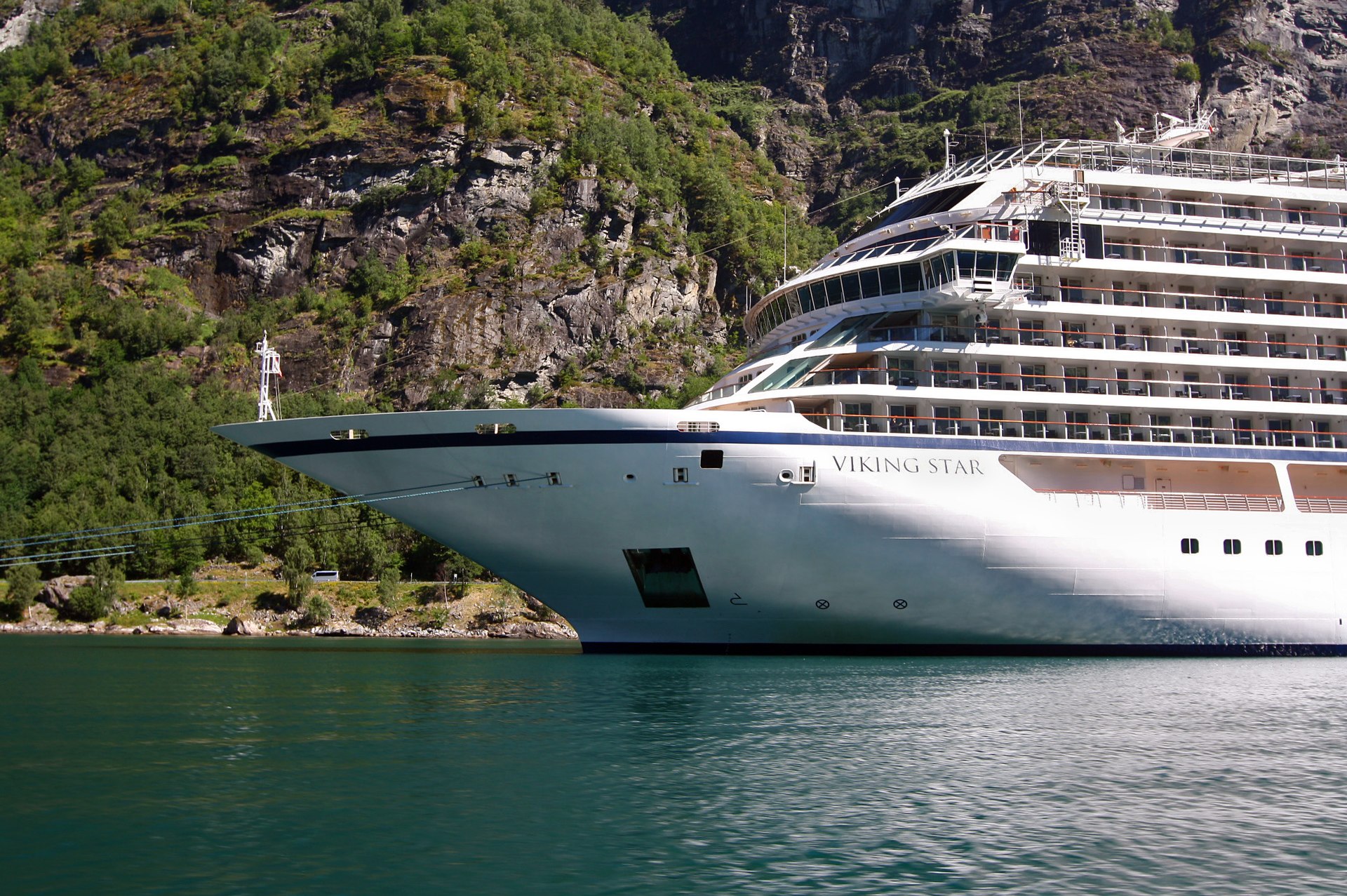 Viking Star cruise ship moored in Geirangerfjord, Norway, beside green cliffs and deep teal water