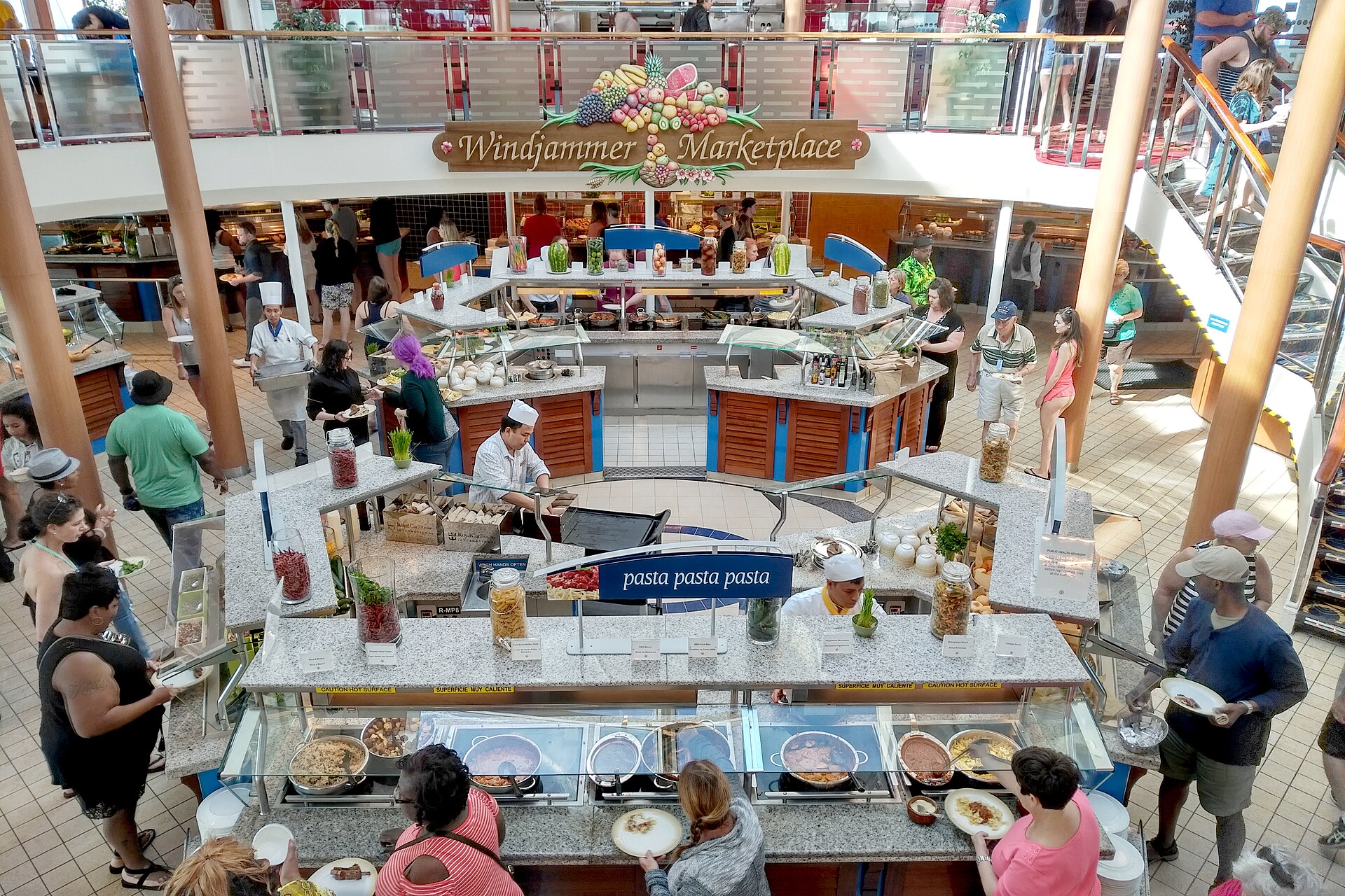 Passengers queuing at the busy Windjammer Marketplace buffet stations on Majesty of the Seas, seen from the deck above