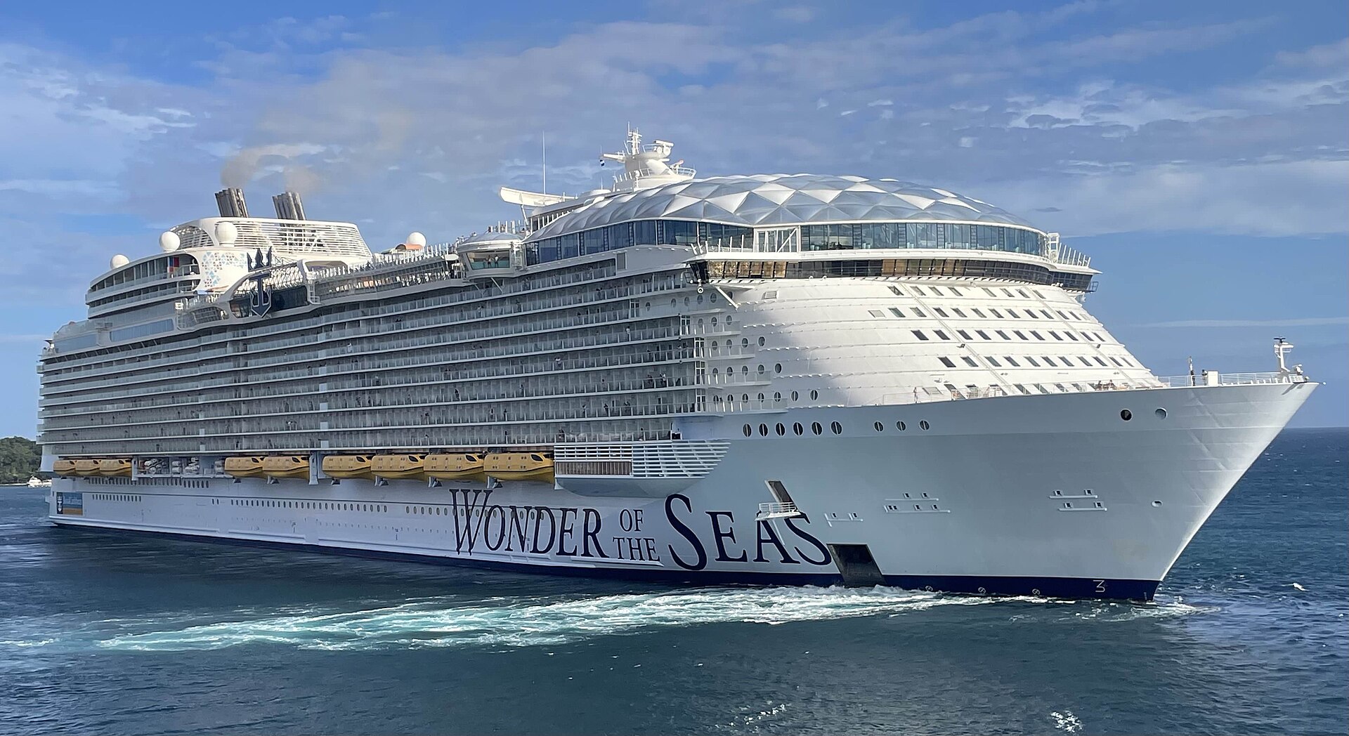 Royal Caribbean's Wonder of the Seas sailing through deep blue water as it departs Roatan, Honduras