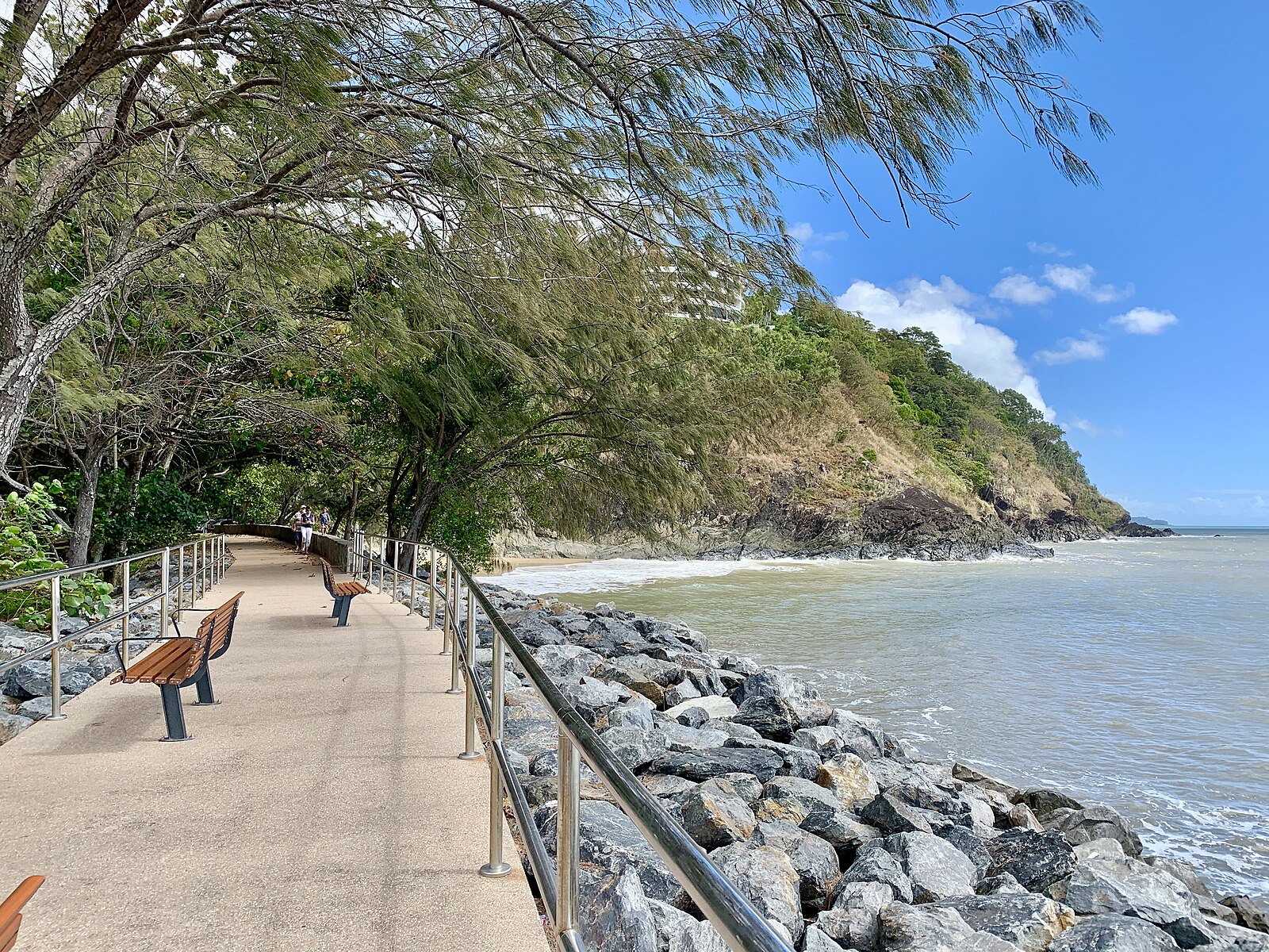 The boardwalk along Yorkeys Knob beach north of Cairns, with turquoise water, green headland and blue sky