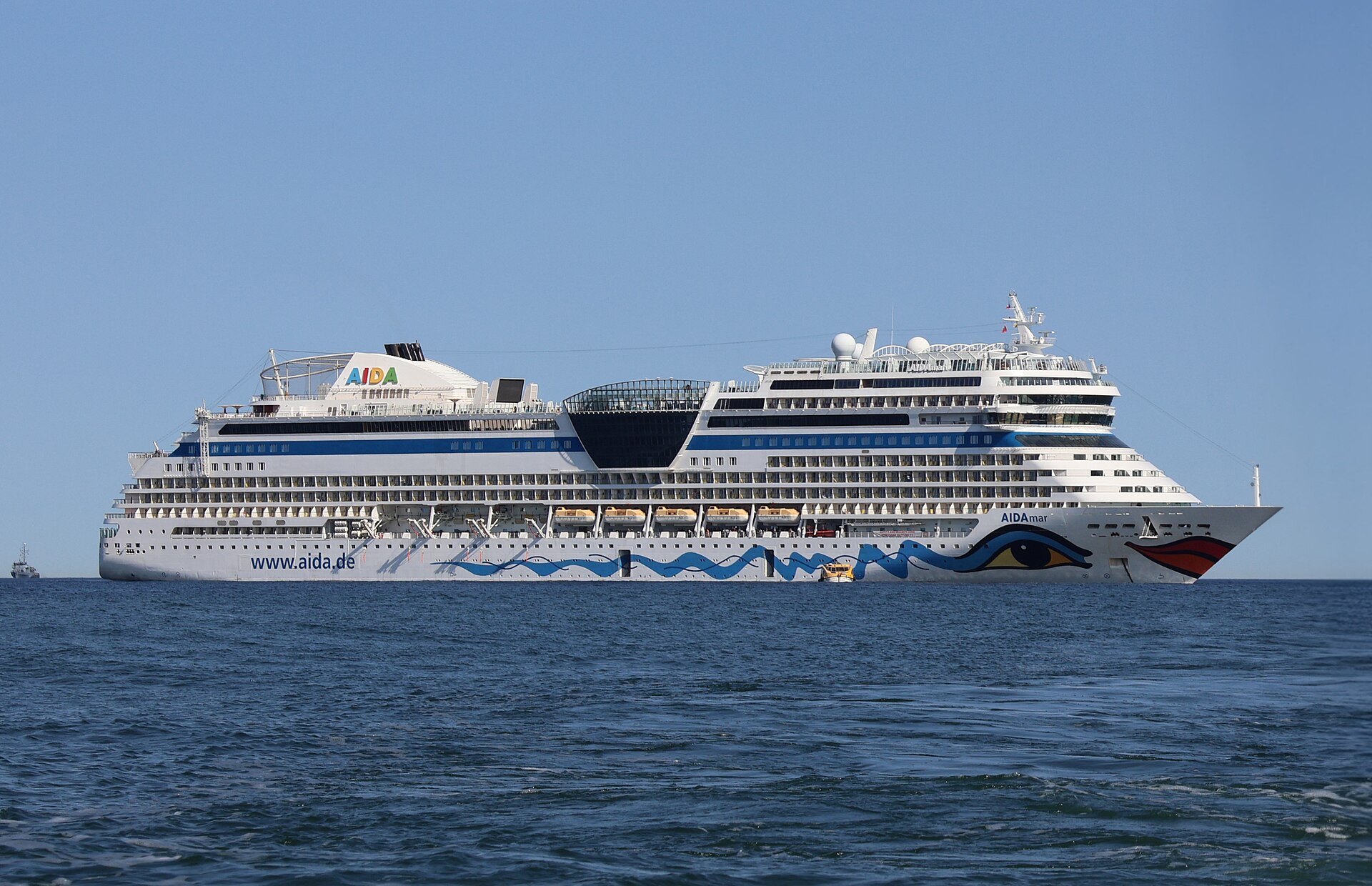 AIDAmar cruise ship with her painted eye and red lips on the bow, on a deep blue sea