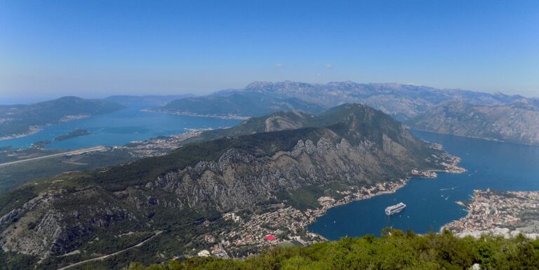A cruise ship anchored in the blue Bay of Kotor, Montenegro, seen from high on the mountains above the old town