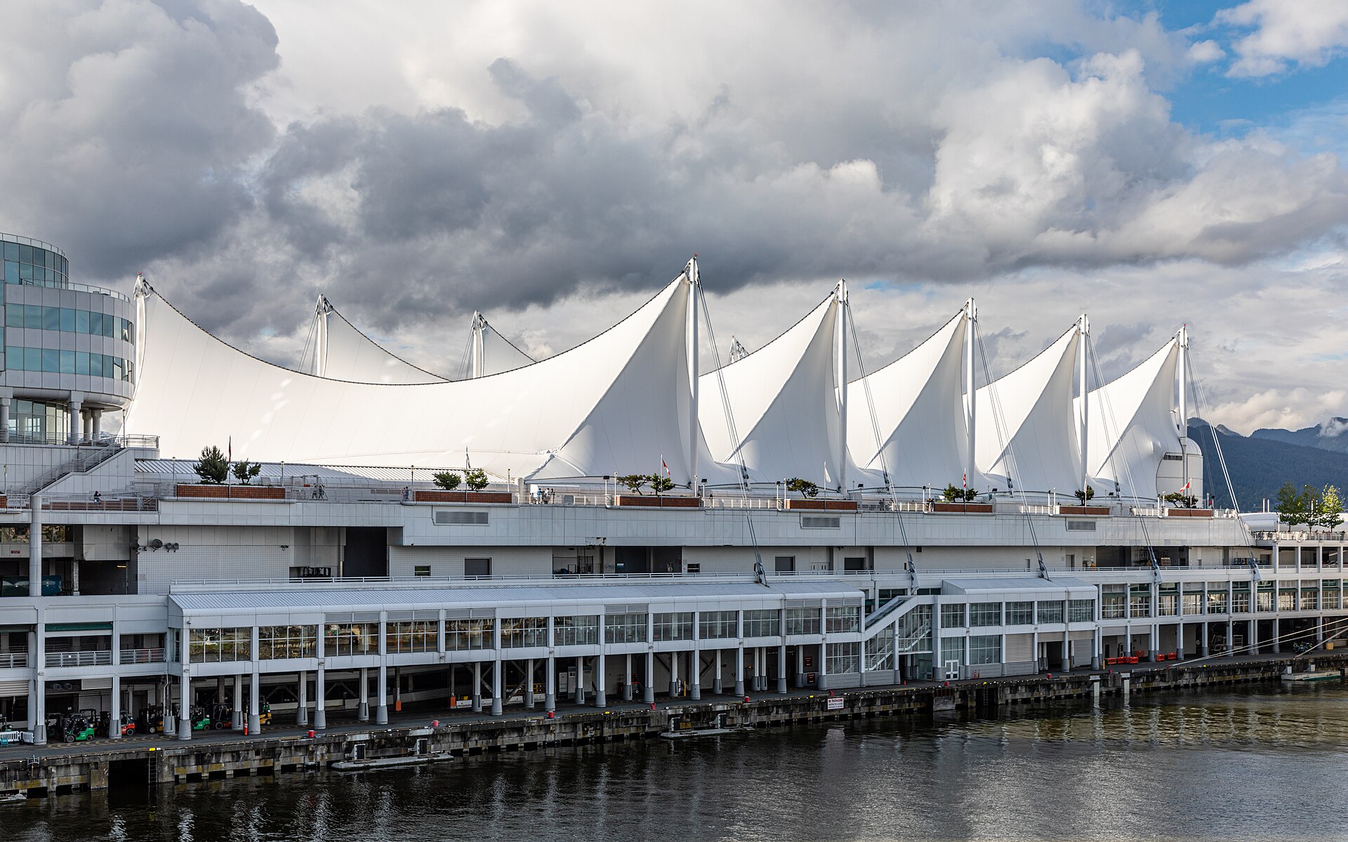 The white sail roofs of Canada Place cruise terminal in Vancouver beside the harbour