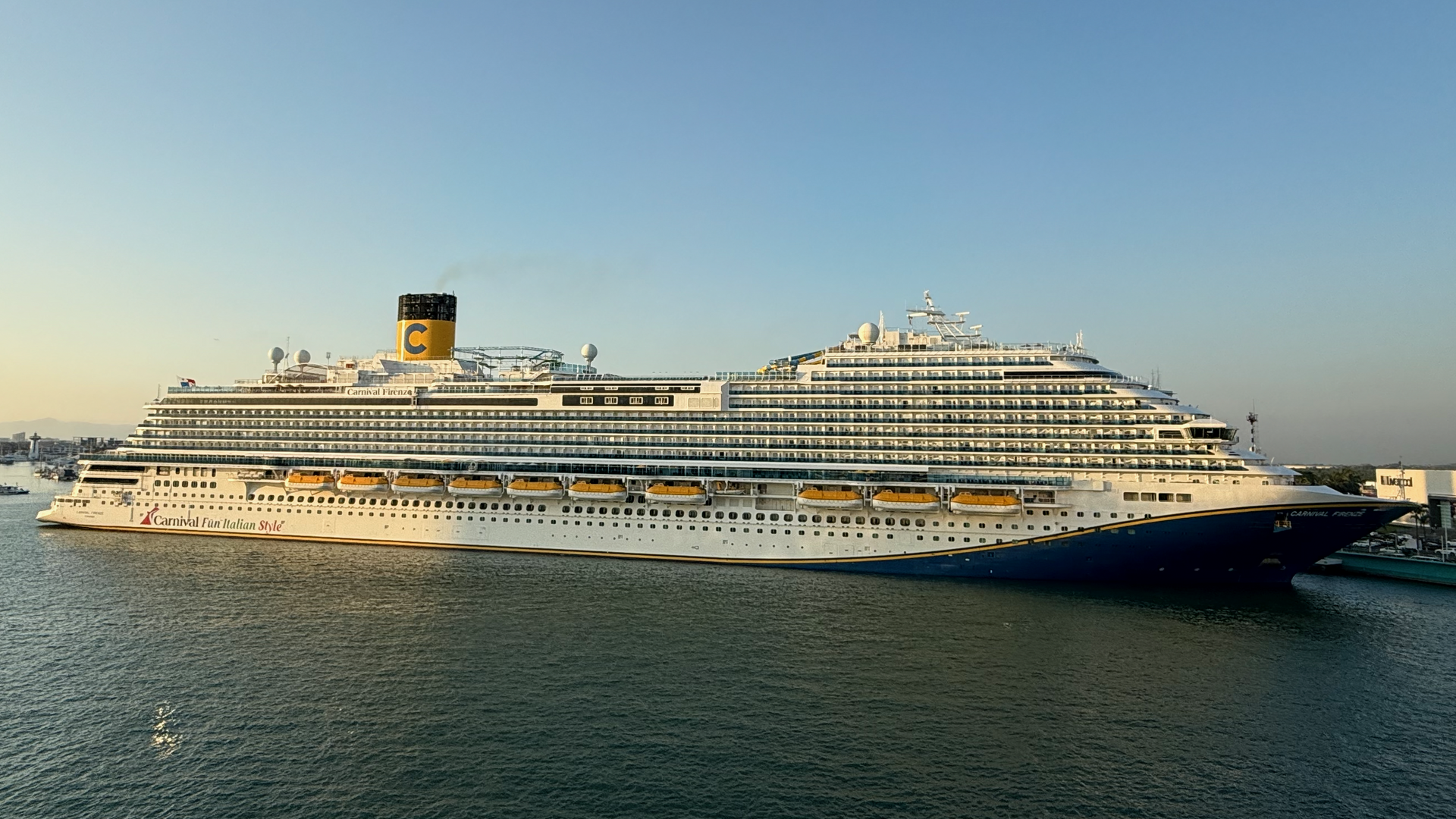 Carnival Firenze in port at Puerto Vallarta in golden evening light on calm blue water