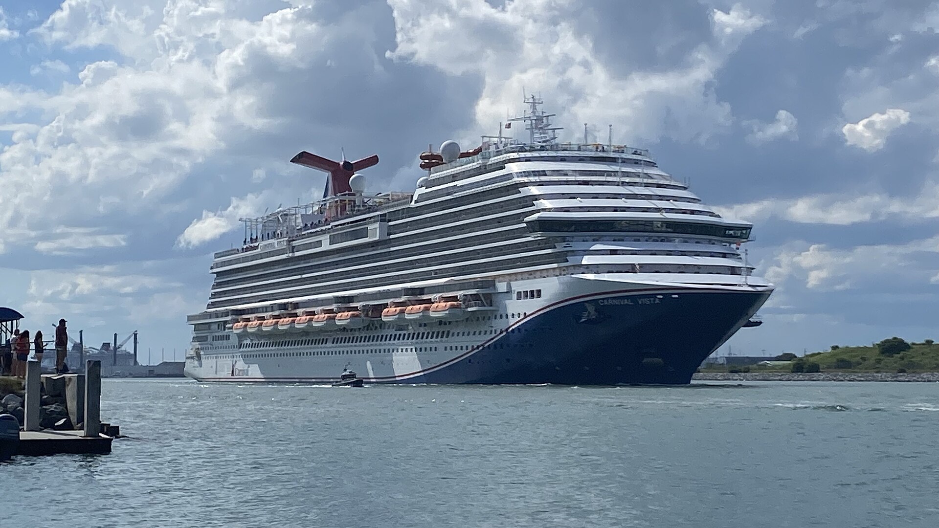Carnival Vista sailing out of Port Canaveral under a blue sky with white clouds