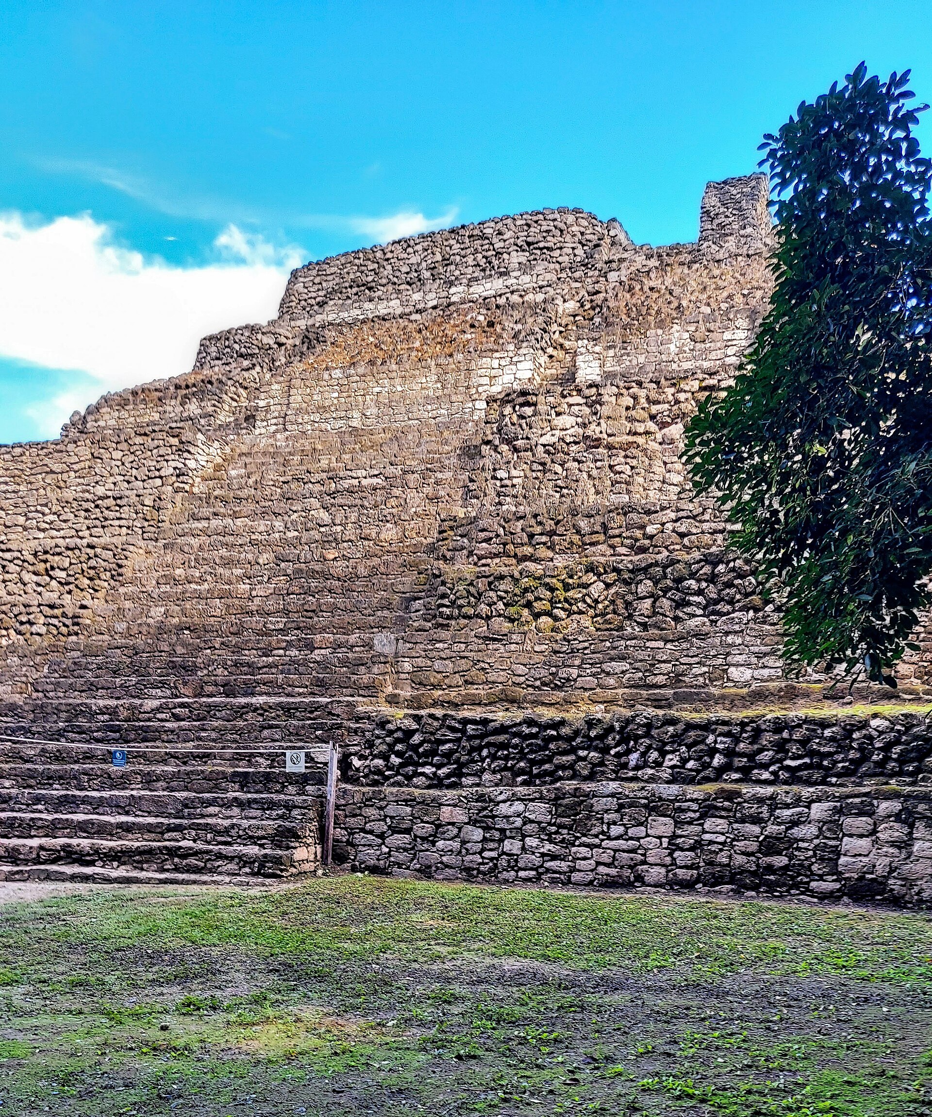 A stepped Maya stone structure at Chacchoben under a blue sky