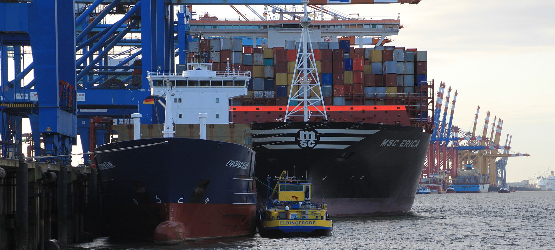 Container ships moored under blue gantry cranes at the Stromkaje container terminal in Bremerhaven
