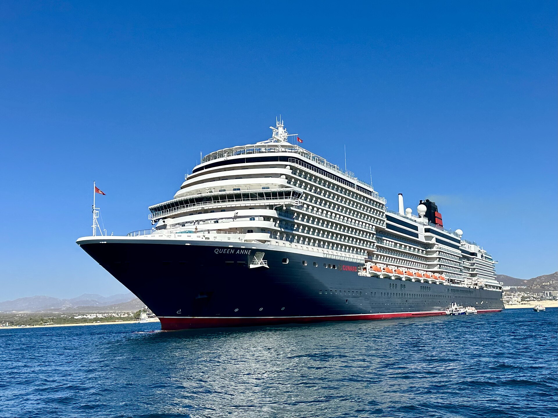 Cunard's Queen Anne cruise ship at anchor under a clear blue sky