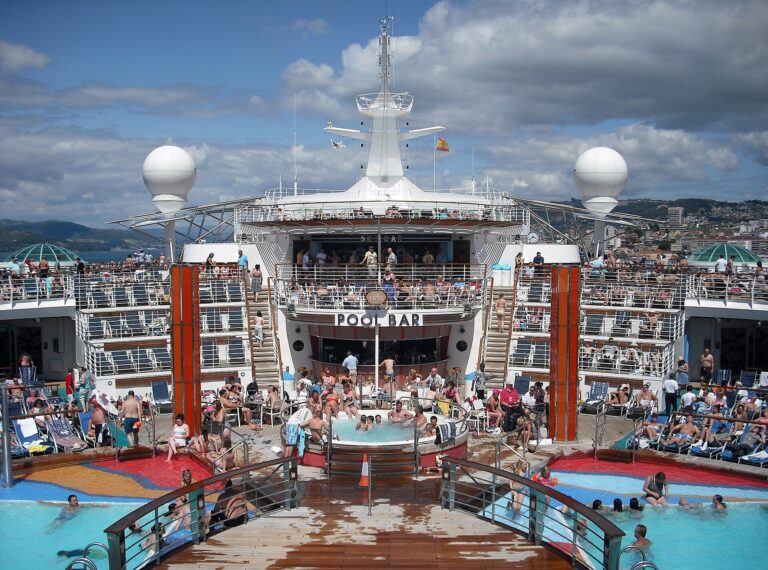 Sunbathers and swimmers around the Pool Bar on the sunny pool deck of Royal Caribbean's Independence of the Seas