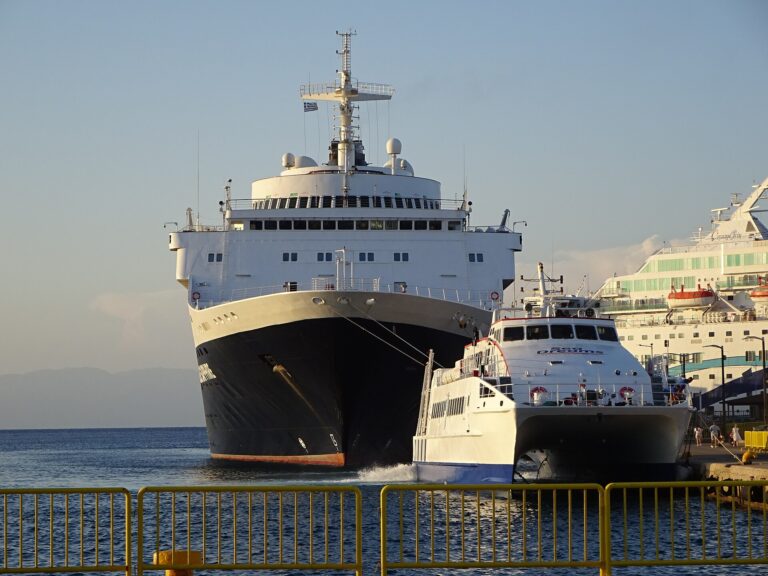 The white and blue catamaran King of Rhodes approaching the quay beside the much larger cruise ship Blue Sapphire in the Port of Rhodes, evening light