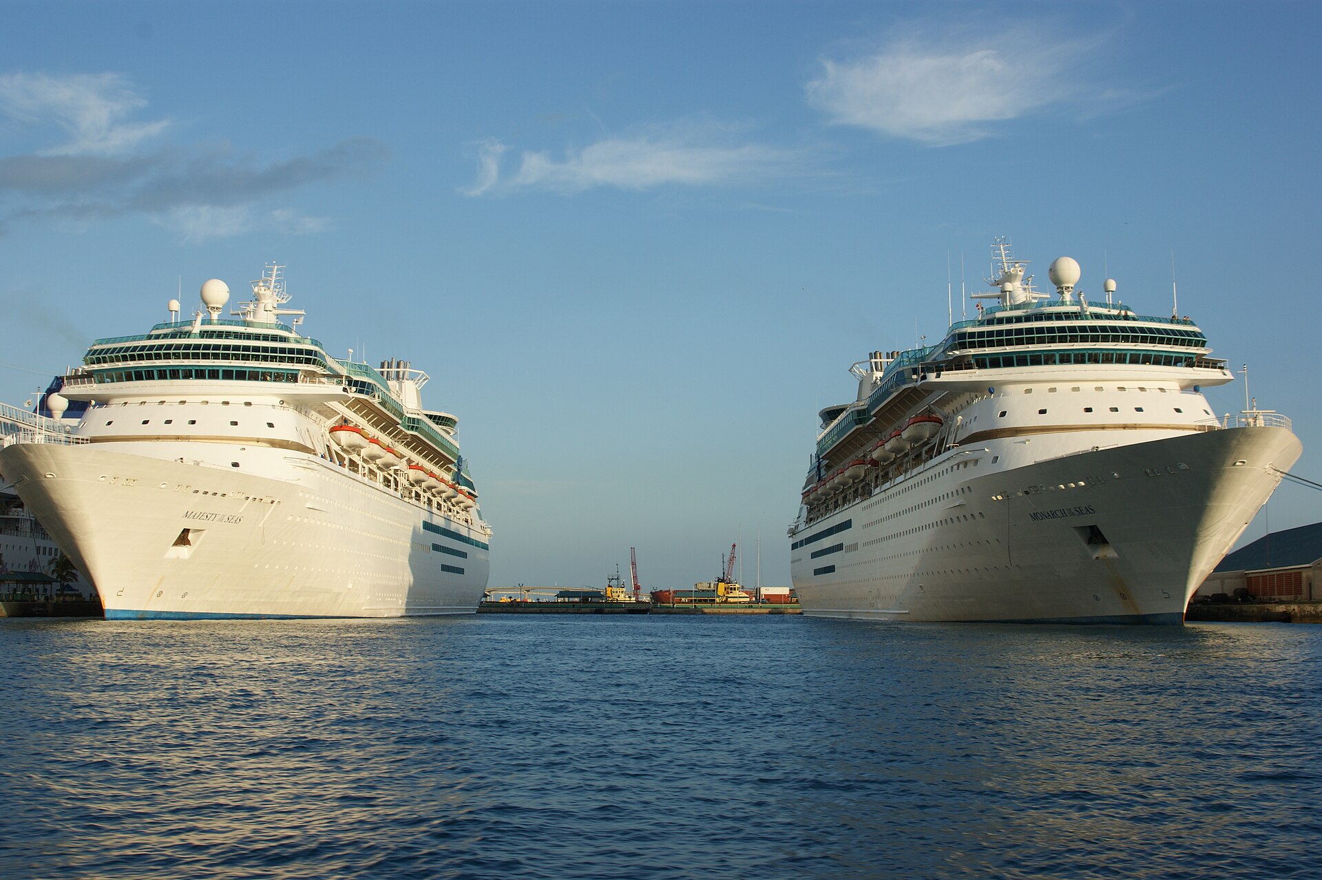 Sister ships Majesty of the Seas and Monarch of the Seas docked facing each other across the blue water of Nassau harbour