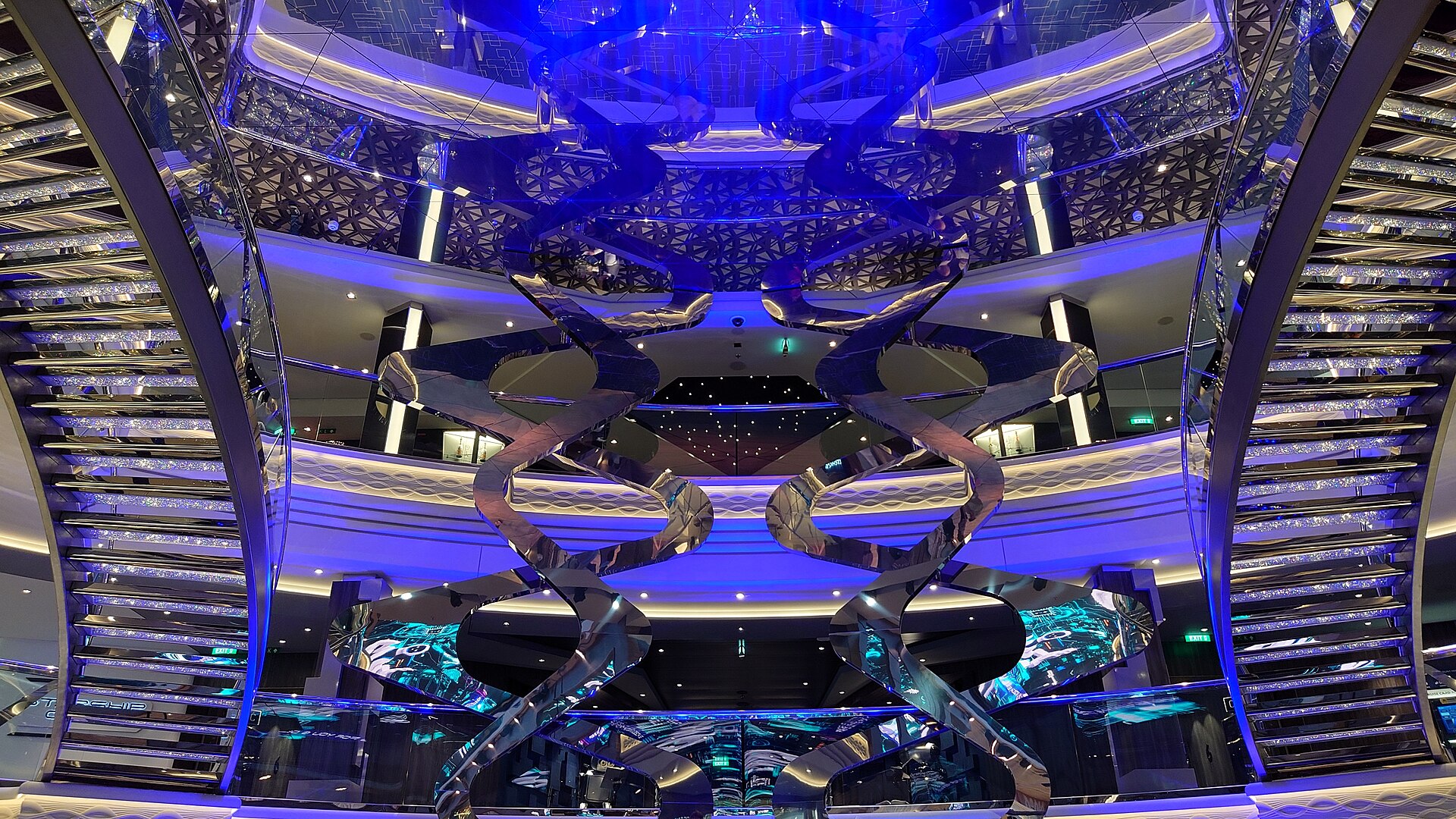 Looking up at MSC Virtuosa's blue-lit atrium with its glittering staircases