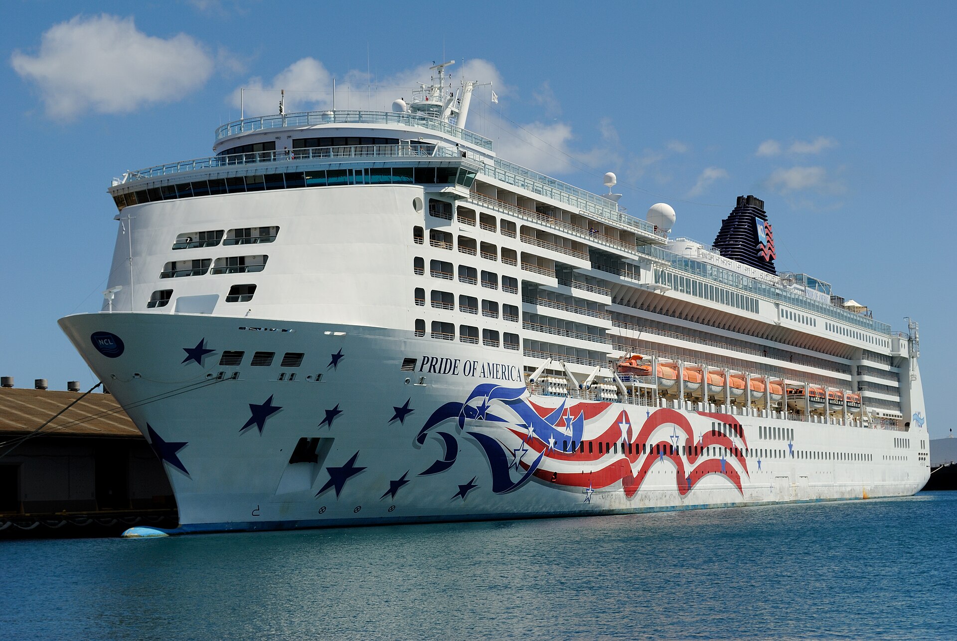 Norwegian's Pride of America with its stars-and-stripes hull art docked in Honolulu under a blue sky