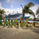 Colorful tropical LABADEE letters and palm trees in front of a Royal Caribbean cruise ship docked at Labadee, Haiti