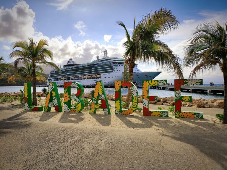Colorful tropical LABADEE letters and palm trees in front of a Royal Caribbean cruise ship docked at Labadee, Haiti