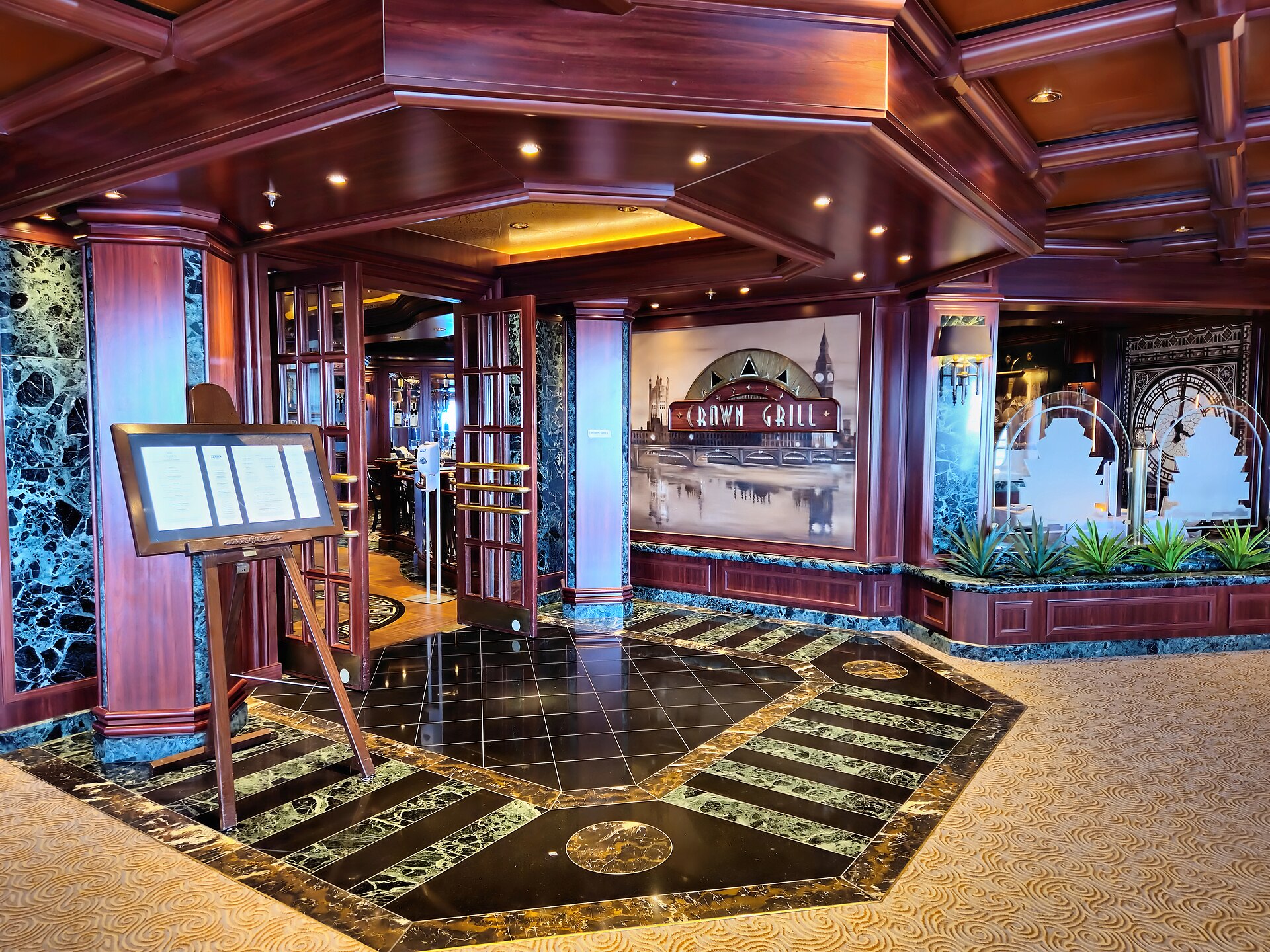 Wood-panelled entrance to the Crown Grill steakhouse on Ruby Princess, with a menu stand and marble floor