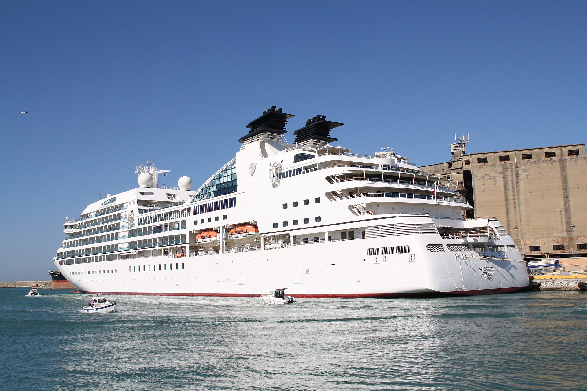 Seabourn Sojourn, a white luxury cruise ship, in port under a clear blue sky