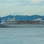 Villa Vie Odyssey residential cruise ship at anchor in front of green hills