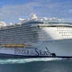 Royal Caribbean's Wonder of the Seas sailing away from Roatan, Honduras, on blue water under a blue sky